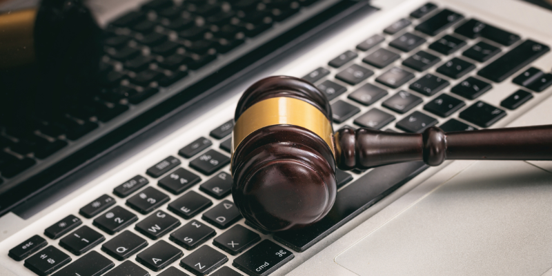 Image of a gavel on top of a laptop.